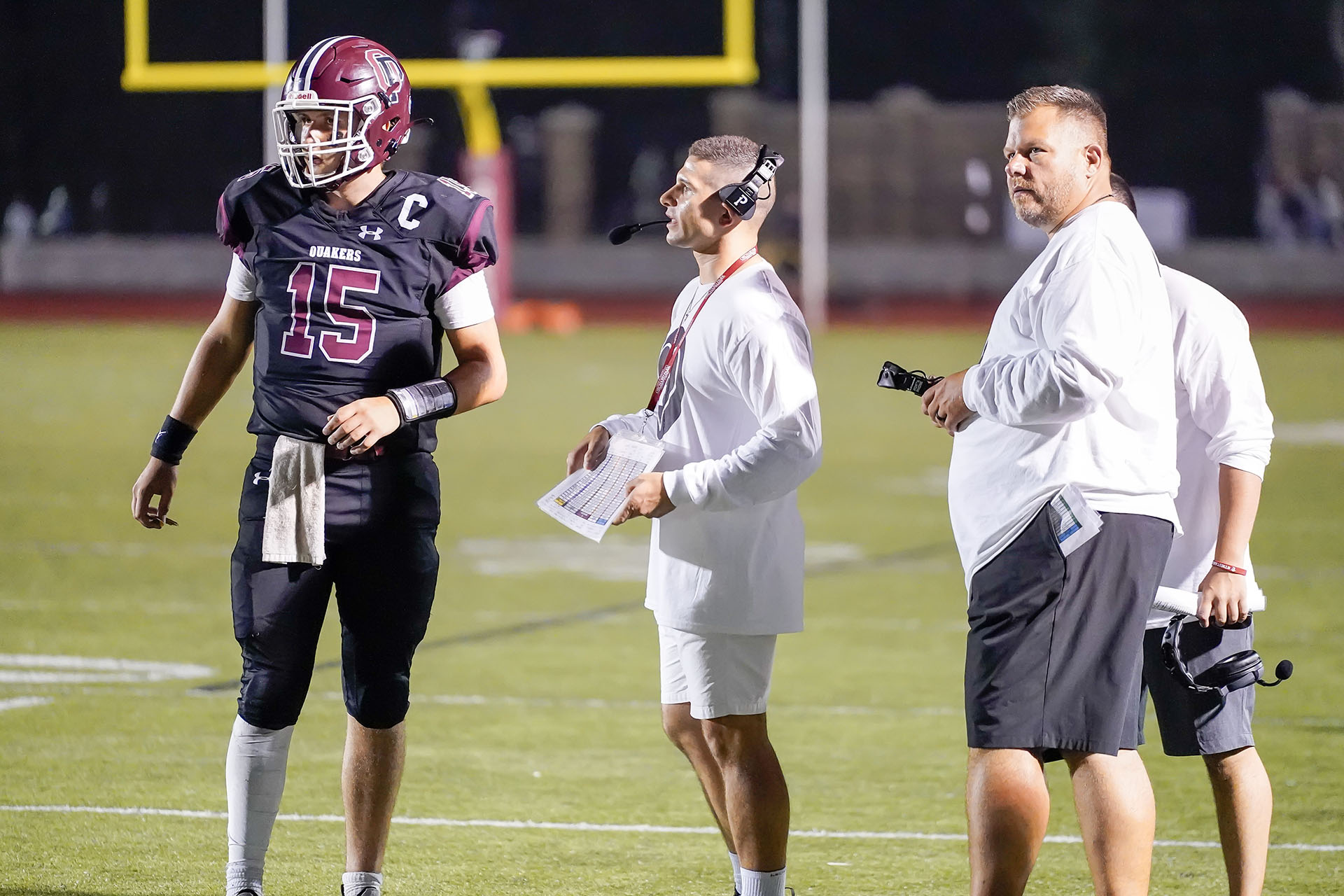 Coaches talking to the QB during a timeout